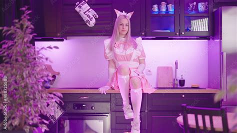 Blonde Girl Maid In Pink Uniform Sitting On Kitchen Counter Posing Stock Photo Adobe Stock