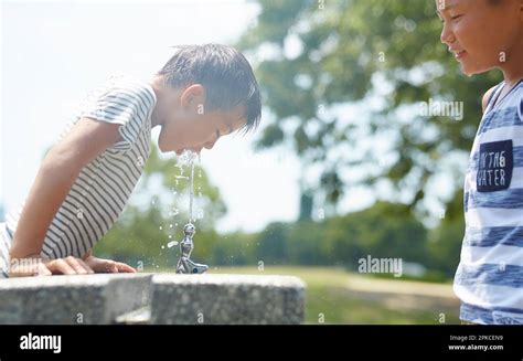 Boy drinking water at water fountain Stock Photo - Alamy