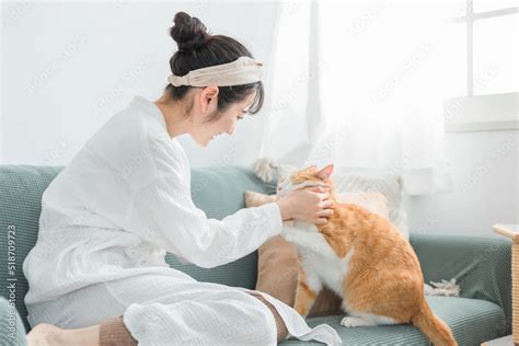 家で猫を抱っこする日本人女性（ペット・飼い主） Stock Foto Adobe Stock