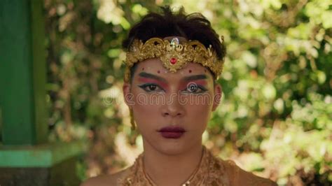 Balinese Man Sitting Peacefully While Meditating In A Golden Crown And