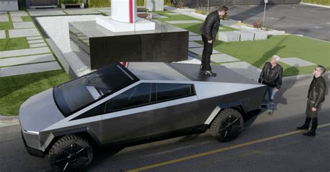 Elon Musk standing on Cybertruck tonneau cover : cybertruck