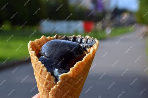 Premium Photo | Cone with black licorice ice cream in hand