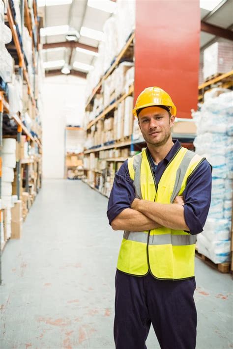 male warehouse worker  safety vest scanning boxes  warehouse aisle