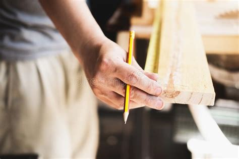 A Carpenter Measures The Planks To Assemble The Parts And Build A