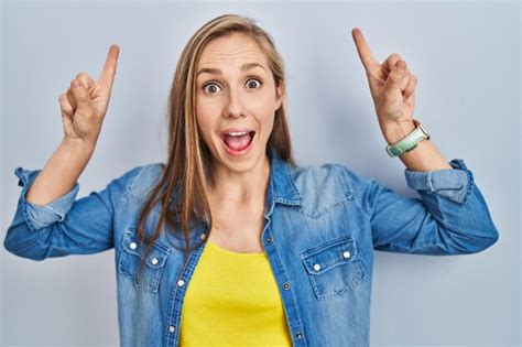 Junge Blonde Frau Steht Vor Blauem Hintergrund L Chelt Erstaunt Und Berrascht Und Zeigt Mit
