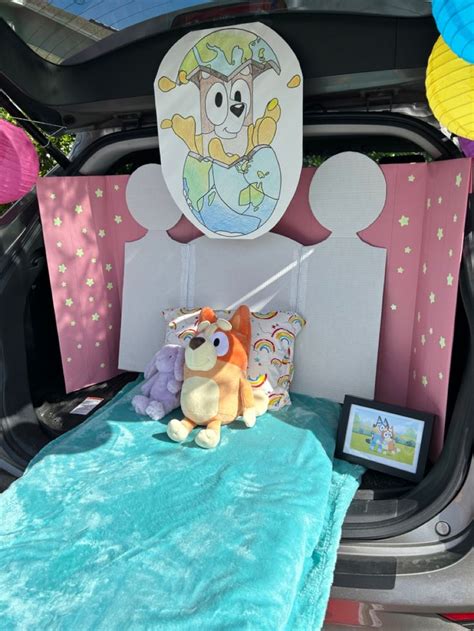 there is a stuffed animal on the bed in the trunk of a car with it's ...