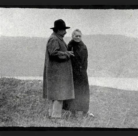 Albert Einstein and Marie Skłodowska Curie reminiscing by a lake in