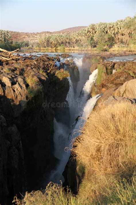 Epupa Falls Waterfall With Baobab Trees At The Border Of Namibia And