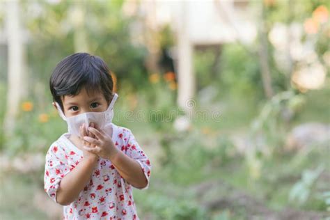 Child Wearing a Protective Face Mask on a City Street with Air ...