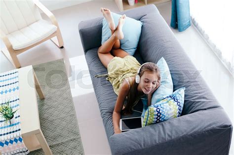 Tween girl relaxing on couch at home | Stock image | Colourbox