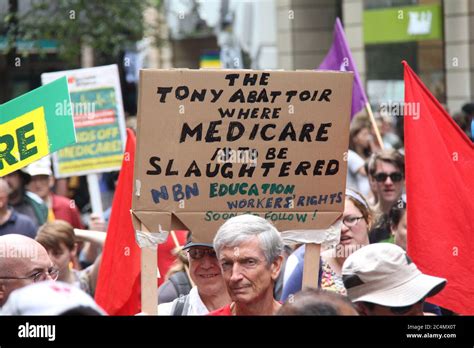 A man at the march carries a sign saying, ‘The Tony Abattoir where