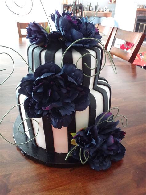 A Black And White Cake With Flowers On Top