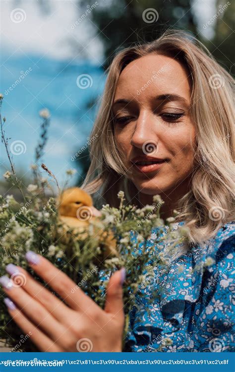 Beautiful Girl Holding Wildflowers And Duckling In Her Hands Stock