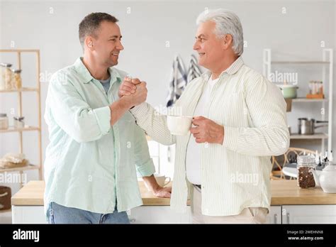 Mature Brothers Holding Hands In Kitchen Stock Photo Alamy