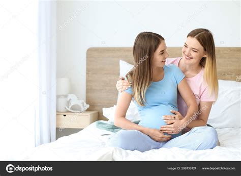 Happy Pregnant Lesbian Couple In Bedroom Stock Photo By Serezniy 299138124