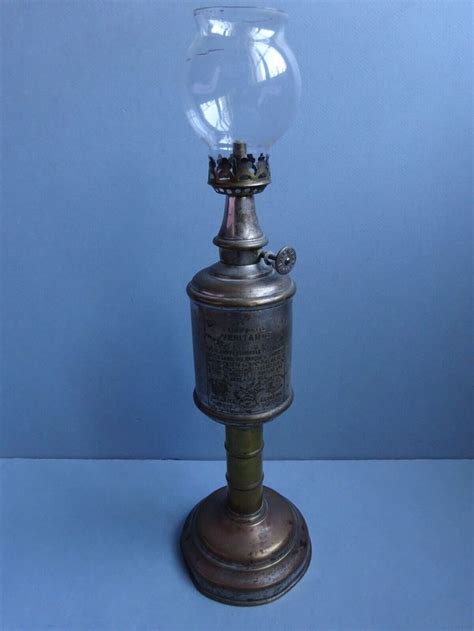 An Antique Oil Lamp With A Glass Globe On Top Sitting On A Blue Background