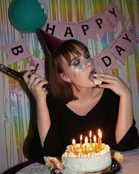 A Woman Is Blowing Out Candles On Her Birthday Cake While Sitting In