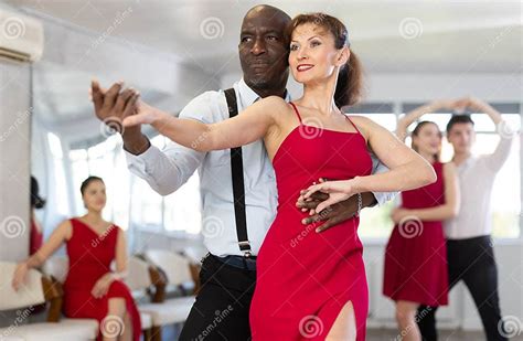 African American Performing Kizomba with Woman in Red in Dance Studio ...