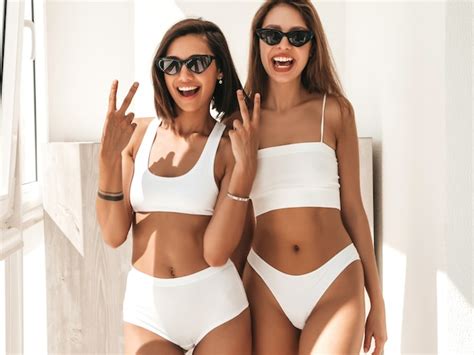 Retrato de duas belas mulheres sorridentes em lingerie branca Foto Grátis