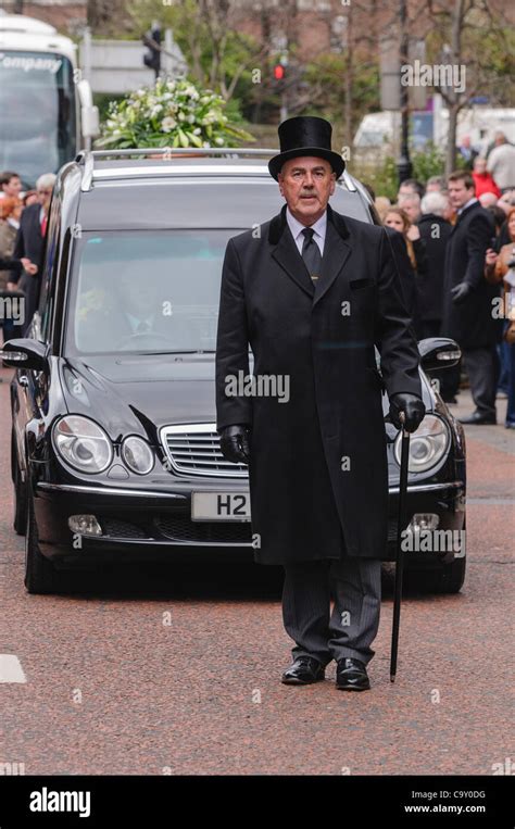 Undertaker 'paging' (walking at the head of the cortege) at a funeral ...