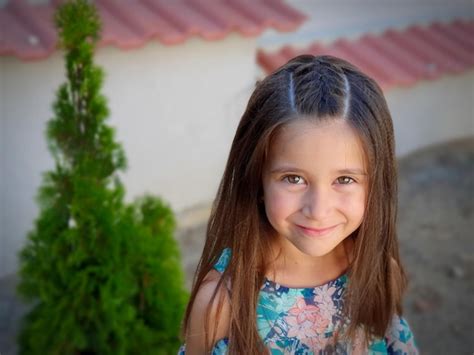 Premium Photo Portrait Of Cute Girl Smiling While Standing On Footpath