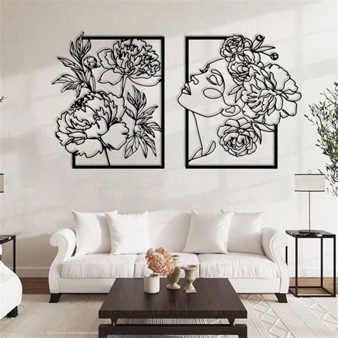 Two Black And White Paintings On The Wall In A Living Room With Couches Coffee Table And Vases