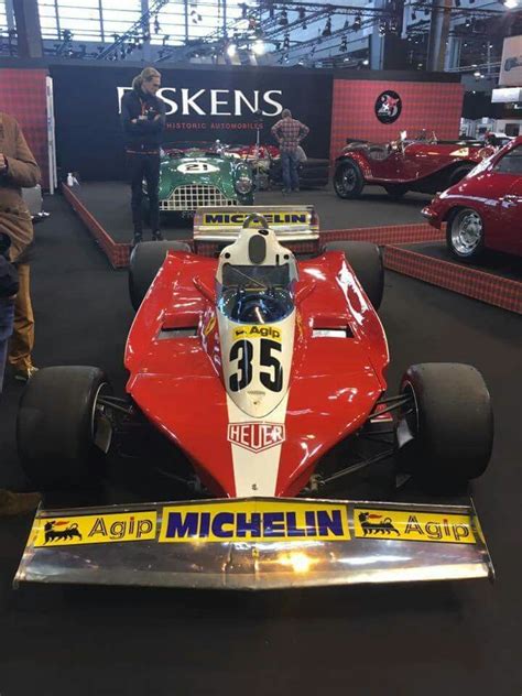 A Red And White Race Car On Display In A Museum