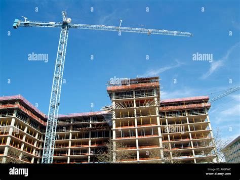 Construction Crane Works On High Rise Building Under Construction