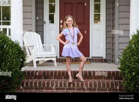 La médaille Sassy Blonde Girl Wearing pose sur le front de brique Étapes Photo Stock Alamy