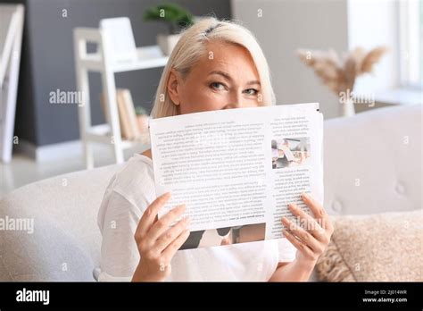 Beautiful Mature Woman Reading Newspaper On Sofa At Home Stock Photo Alamy
