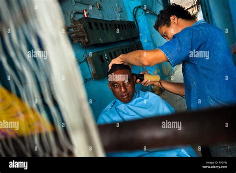 A Cuban Hairdresser Cuts A Mans Hair In An Improvised Barber Shop In A