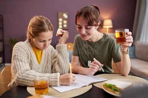 Joven Madre Militar Ayudando A Su Hija A Hacer Los Deberes Y Almorzando