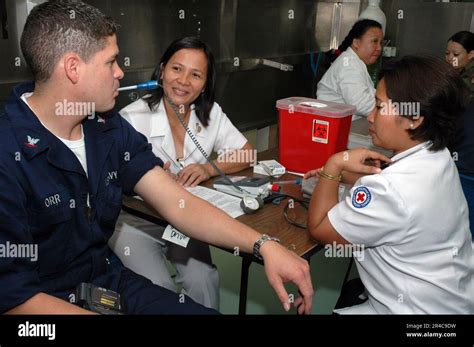 US Navy Nurses for the Philippine National Red Cross, takes a ...