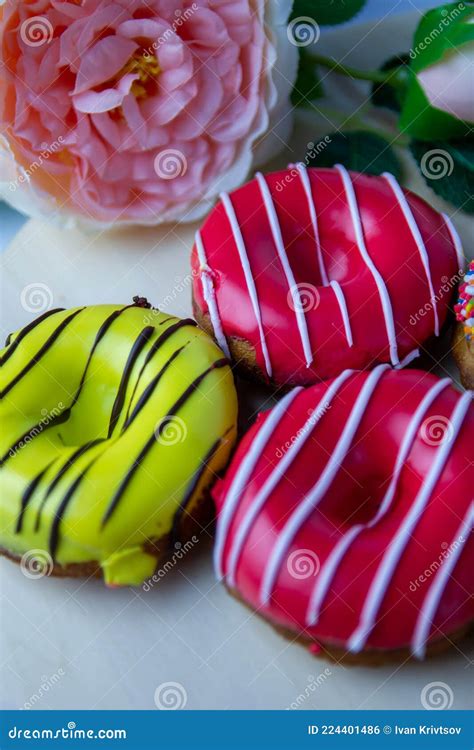 Drie Donuts Van Verschillende Kleuren Liggen Op Een Houten Standaard