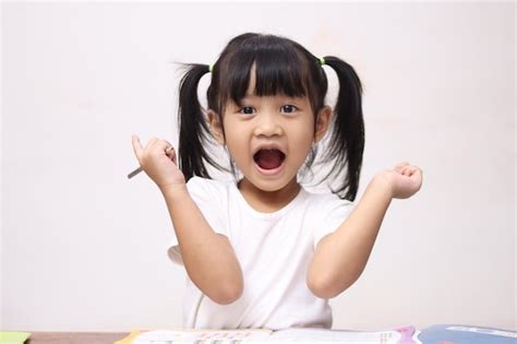 Cute pequena menina asiática levantando as mãos para cima sorriso feliz