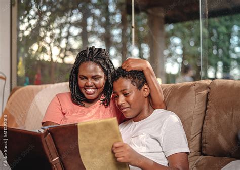 Mulher Latina Abra Ando Seu Filho Enquanto Mostra Lbum De Fotos Para Ele No Sof Da Sala No Dia