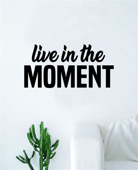 Live In The Moment Wall Sticker On A White Wall Next To A Potted Cactus