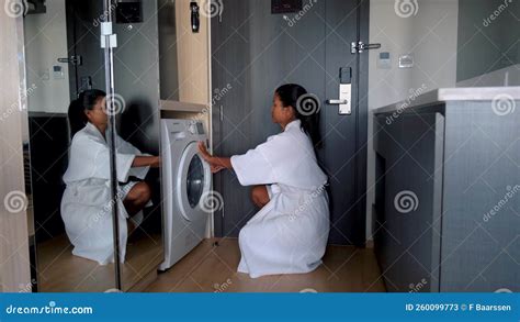 Thai Asian Women Doing The Laundry Putting Clothes In Wash Machine