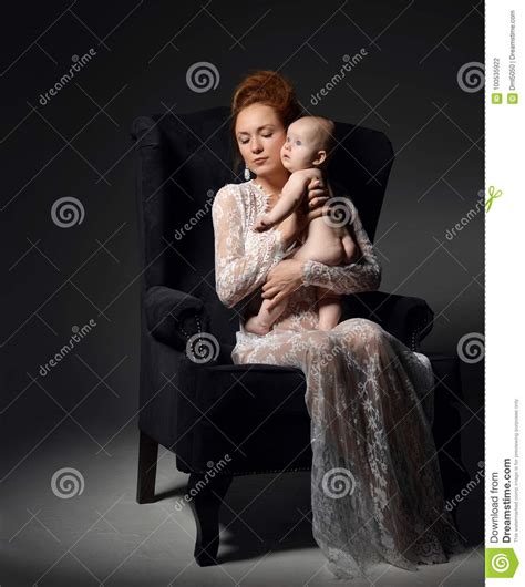 Giovane Seduta E Tenuta Della Donna Della Madre Nude Il Suo Bambino Infantile Adorabile Del