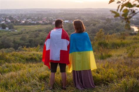 Premium Photo Couple Covered In Ukraine And Switzerland Flags