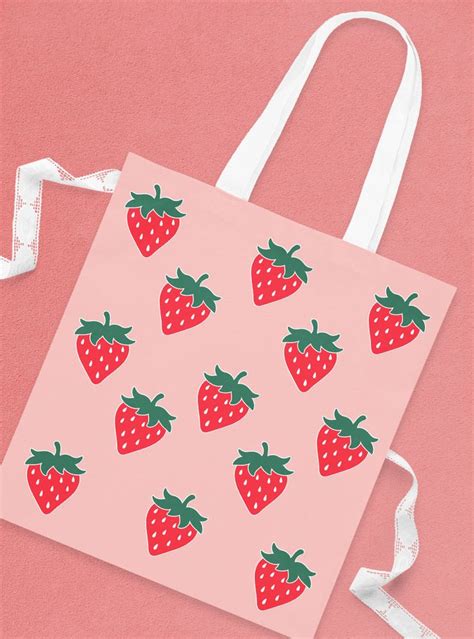 A Pink Shopping Bag With Strawberries On The Front And White Ribbon