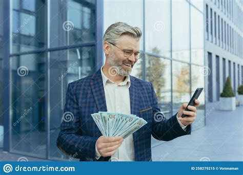 Happy Mature Gray Haired Businessman Holding Winnings Money Cash In Hands Scared Man Smiling