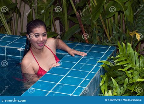 Pretty Asian Woman Wearing Red Bikini Swimming At Swimming Pool And Enjoying Travel On Vacation
