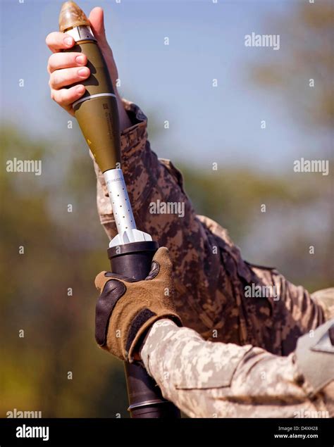 A 60mm Mortar Shell Is Held Over A Tube Ready To Drop And Launch At