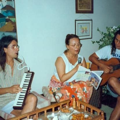 Three People Sitting In A Living Room Playing Instruments