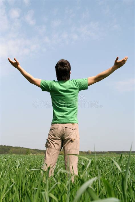 a man standing in the middle of a field with his arms outstretched