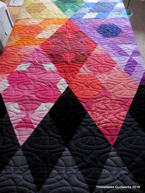 A Colorful Quilt On Top Of A Bed