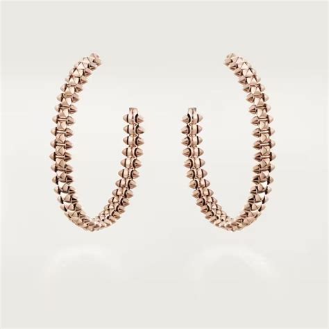 A Pair Of Gold Hoop Earrings With Spikes On The Inside And Outside Of