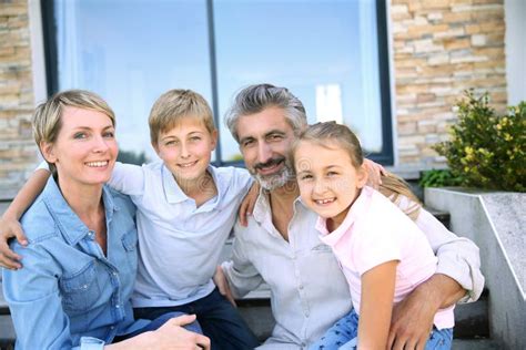 Famille Heureuse S asseyant Devant La Maison Photo stock Image du âgé