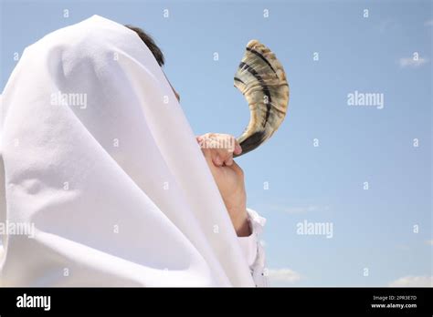 Jewish Man In Tallit Blowing Shofar Outdoors Rosh Hashanah Celebration